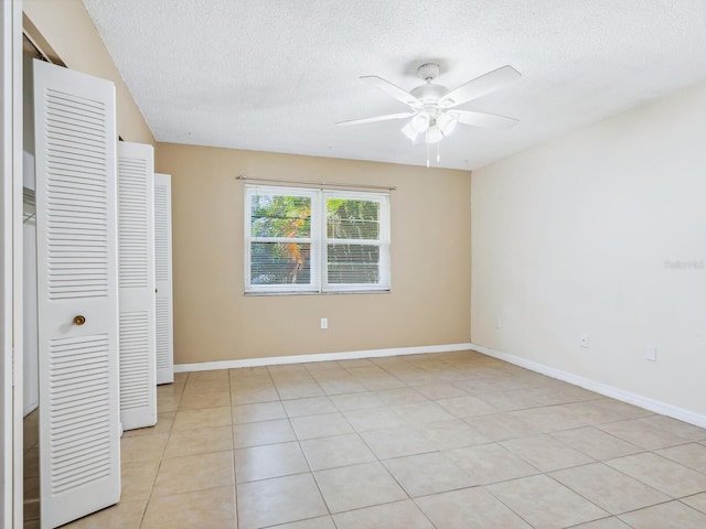 interior space featuring light tile patterned flooring, a textured ceiling, and ceiling fan