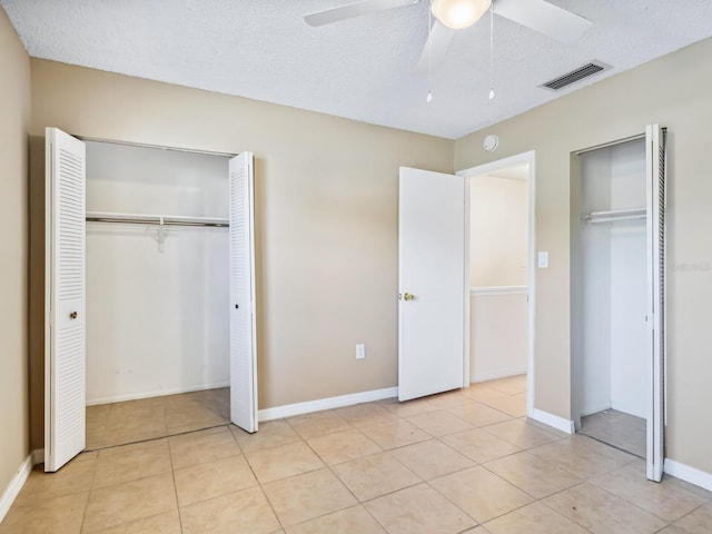 unfurnished bedroom featuring a textured ceiling, ceiling fan, and light tile patterned floors