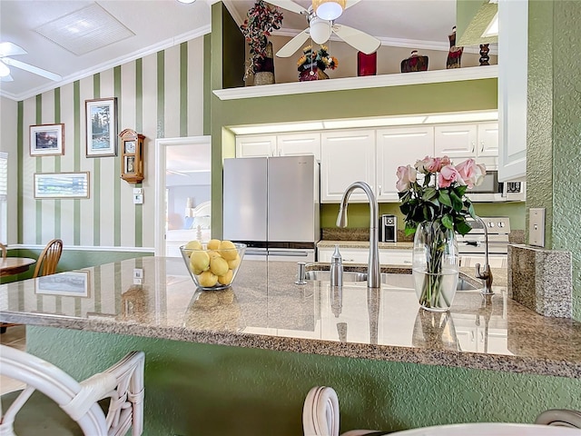 kitchen with white cabinetry, refrigerator, ceiling fan, range with electric cooktop, and ornamental molding