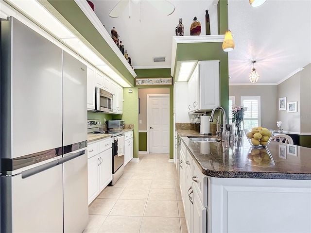 kitchen featuring appliances with stainless steel finishes, sink, hanging light fixtures, crown molding, and white cabinetry