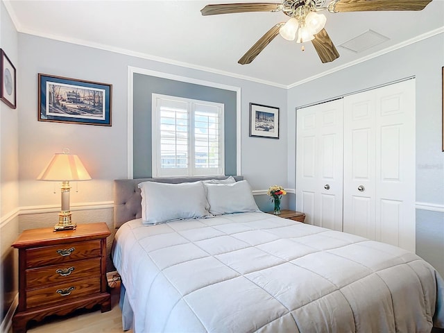 bedroom featuring ceiling fan, light wood-type flooring, a closet, and ornamental molding