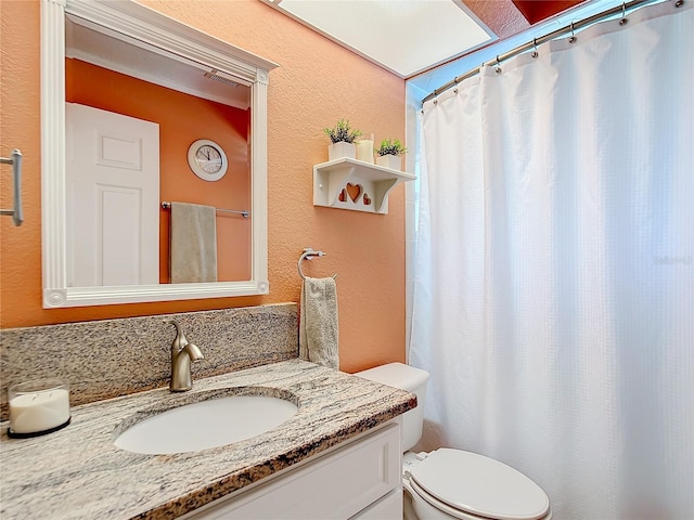 bathroom with toilet and vanity