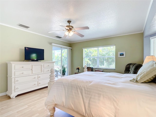 bedroom with light wood-type flooring, ceiling fan, ornamental molding, and a textured ceiling