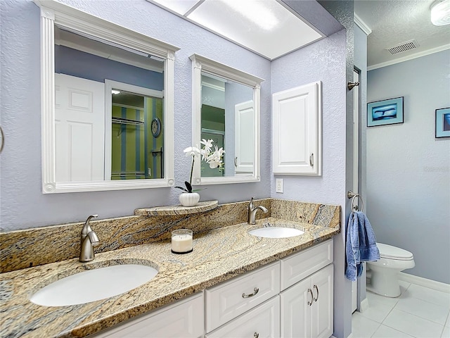 bathroom featuring tile patterned flooring, toilet, and double sink vanity