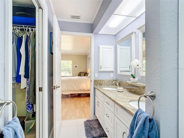 bathroom with dual vanity, hardwood / wood-style flooring, and crown molding