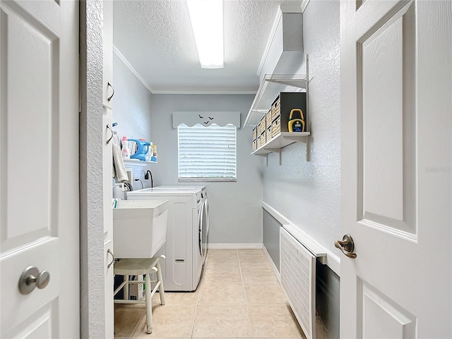 laundry area featuring a textured ceiling, washer and dryer, light tile patterned floors, and ornamental molding