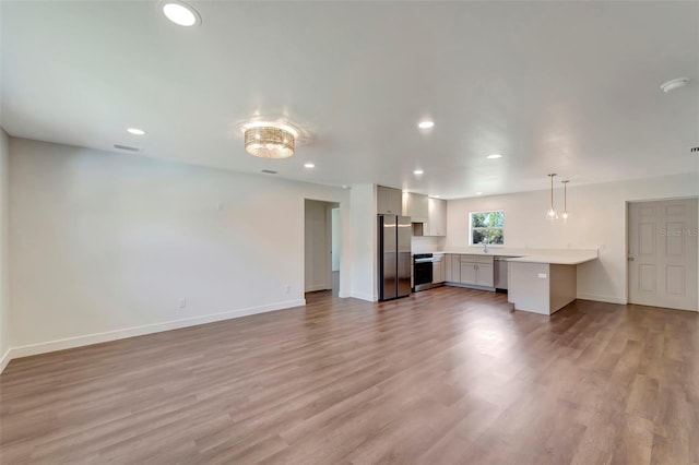 unfurnished living room featuring sink and hardwood / wood-style flooring