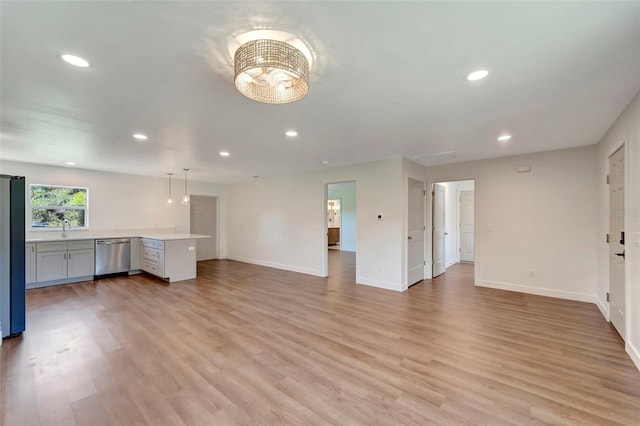 unfurnished living room featuring light wood-type flooring and sink