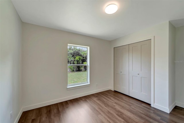 unfurnished bedroom featuring hardwood / wood-style floors and a closet