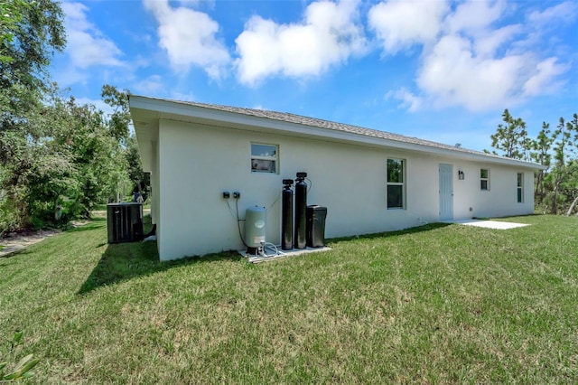 back of house with a yard and central AC unit