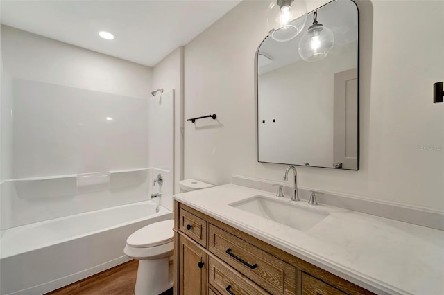 full bathroom featuring hardwood / wood-style flooring, vanity, bathing tub / shower combination, and toilet