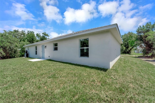 back of property featuring a lawn