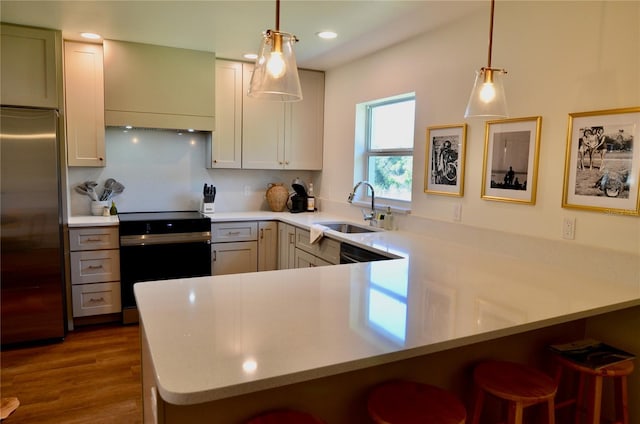 kitchen with stainless steel built in refrigerator, sink, electric range, kitchen peninsula, and pendant lighting