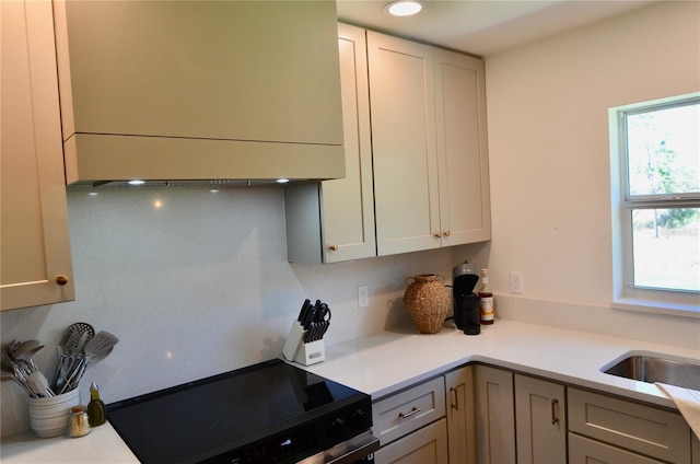 kitchen with ventilation hood, sink, gray cabinetry, and electric stove