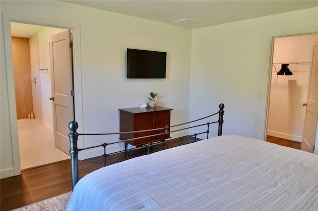 bedroom featuring a spacious closet and hardwood / wood-style floors