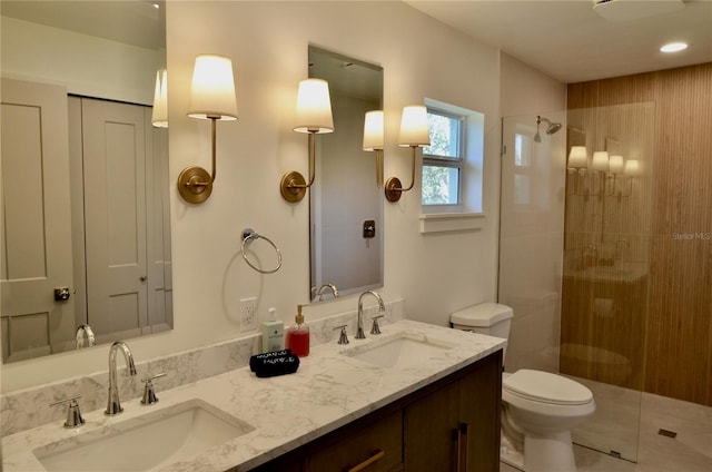 bathroom featuring vanity, tile patterned flooring, toilet, and a tile shower