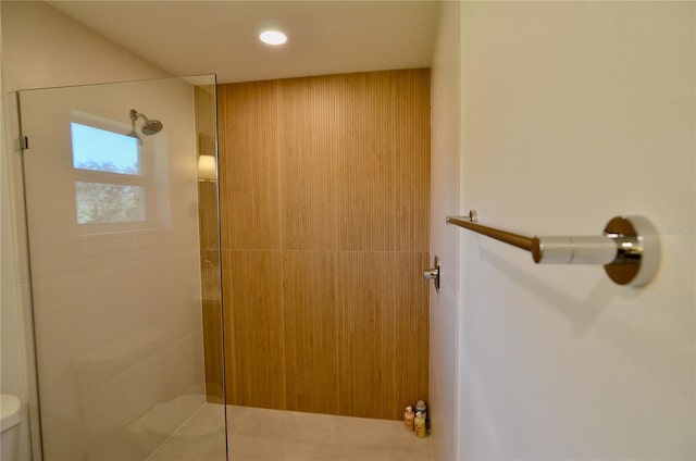 bathroom featuring a tile shower and toilet