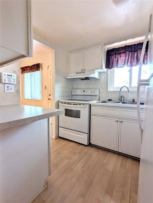 kitchen with tasteful backsplash, electric stove, light hardwood / wood-style flooring, and white cabinets