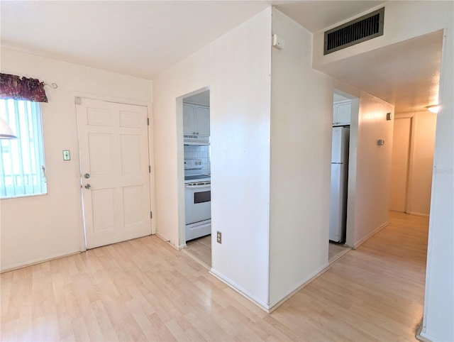 foyer featuring light wood-style floors and visible vents