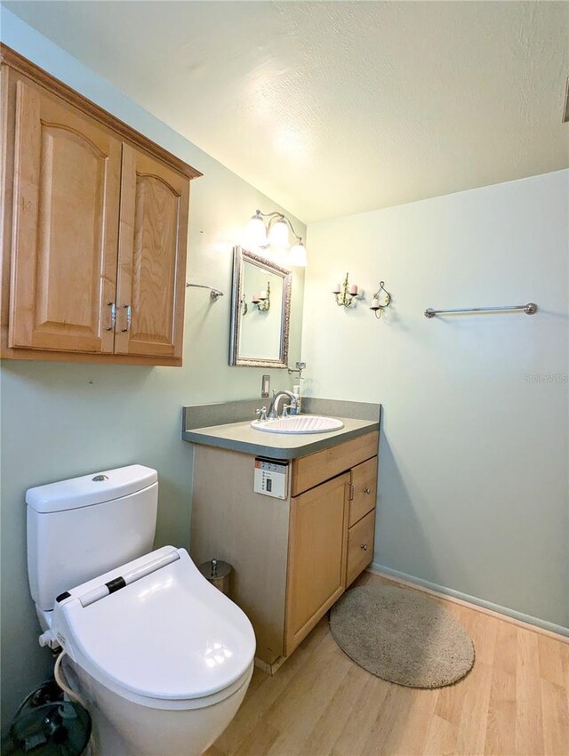 bathroom with vanity, toilet, and hardwood / wood-style floors