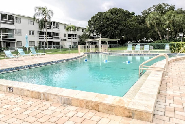 community pool featuring a patio area and fence