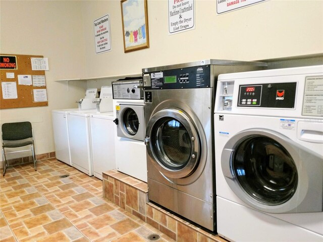 clothes washing area featuring light tile patterned flooring and washing machine and clothes dryer