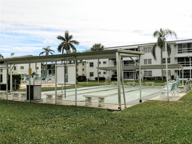 view of home's community featuring a lawn and shuffleboard