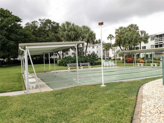 view of home's community with shuffleboard and a yard