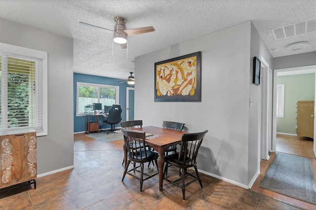 dining space with tile patterned floors, a textured ceiling, and ceiling fan