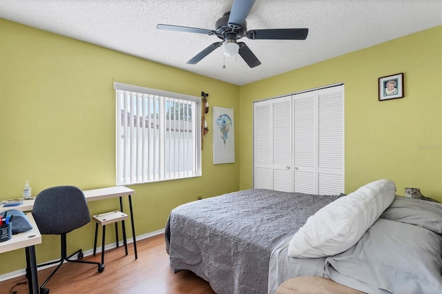 bedroom with a closet, a textured ceiling, ceiling fan, and hardwood / wood-style floors