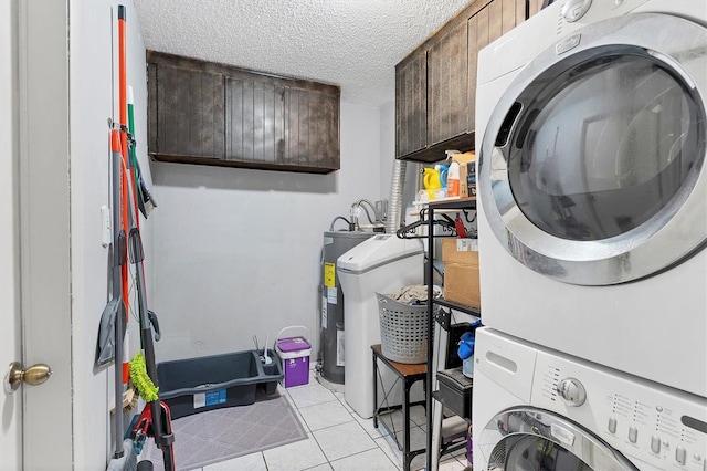 washroom with electric water heater, cabinets, light tile patterned floors, a textured ceiling, and stacked washer / dryer