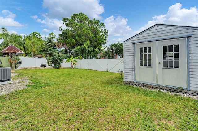 view of yard featuring a shed and central AC unit