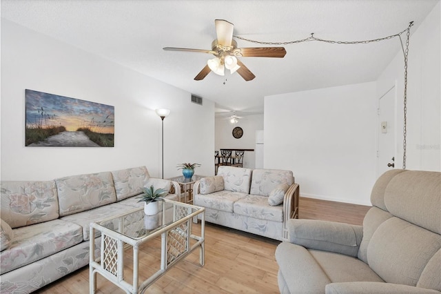 living room featuring light hardwood / wood-style flooring and ceiling fan