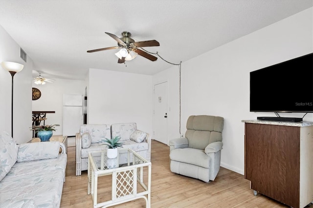 living room with light hardwood / wood-style floors and ceiling fan