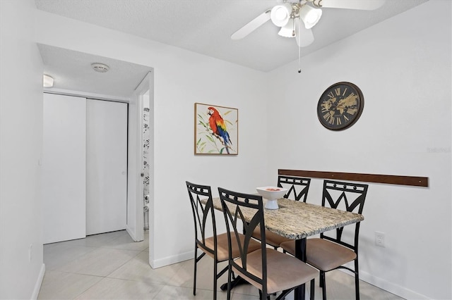 dining area featuring light tile patterned flooring, a textured ceiling, and ceiling fan