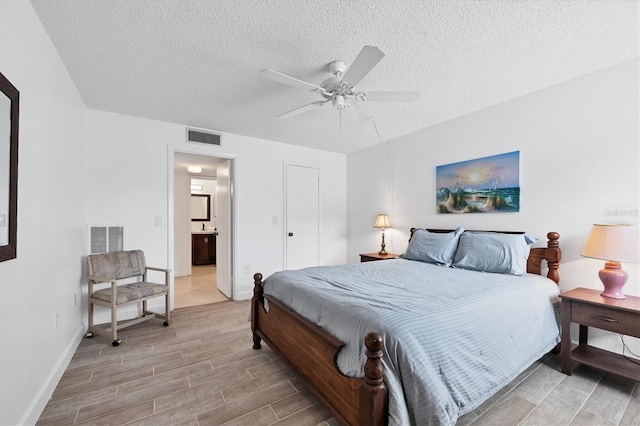 bedroom featuring a textured ceiling, ceiling fan, and connected bathroom