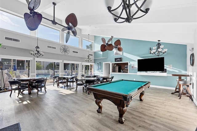 game room with an inviting chandelier, high vaulted ceiling, light wood-type flooring, and billiards