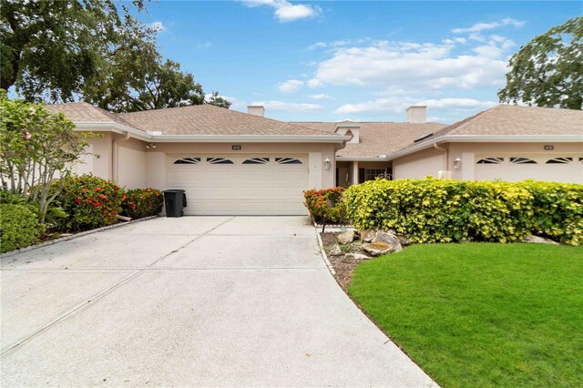 ranch-style home with a garage and a front lawn