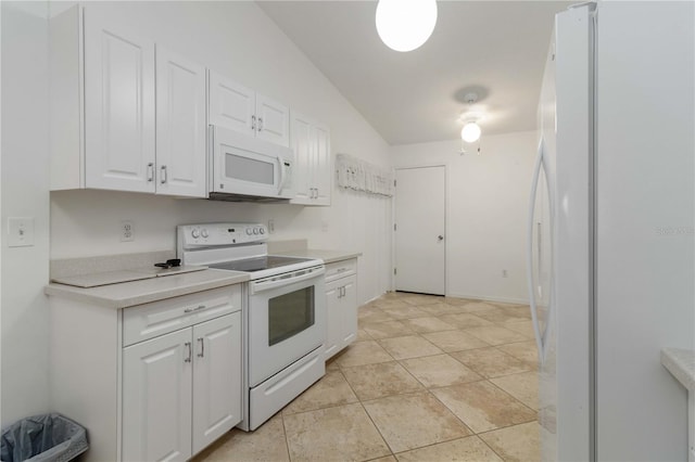 kitchen featuring light tile patterned flooring, white cabinets, vaulted ceiling, and white appliances