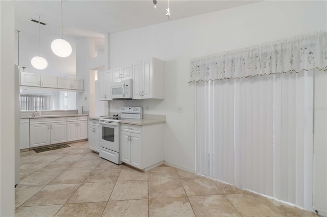 kitchen featuring light tile patterned flooring, white cabinetry, white appliances, and decorative light fixtures