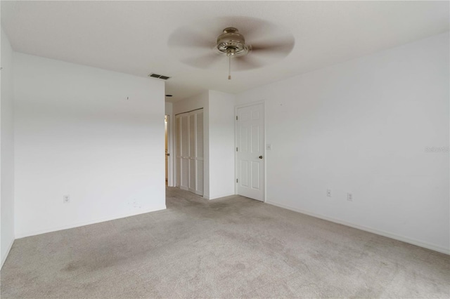 unfurnished room with ceiling fan and light colored carpet