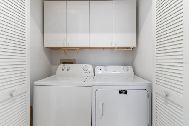 washroom featuring cabinets and independent washer and dryer