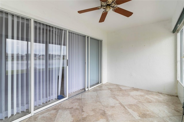 tiled spare room with ceiling fan