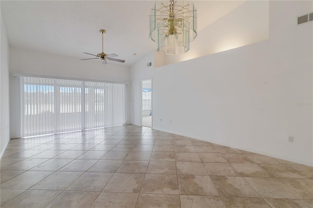 tiled empty room with ceiling fan with notable chandelier, high vaulted ceiling, and plenty of natural light