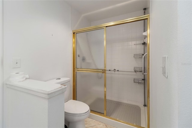 bathroom with a shower with shower door, tile patterned floors, and toilet