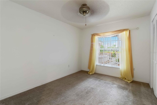 spare room featuring carpet and ceiling fan