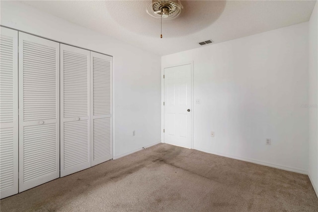 unfurnished bedroom featuring light colored carpet, a closet, and ceiling fan