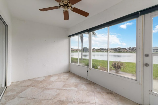 unfurnished sunroom with a water view, a wealth of natural light, and ceiling fan