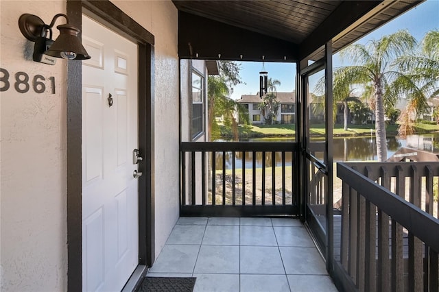 unfurnished sunroom featuring wooden ceiling, a water view, and vaulted ceiling