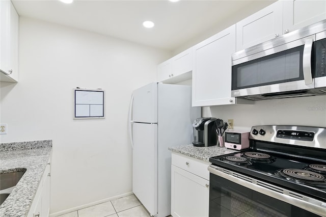 kitchen with white cabinetry, appliances with stainless steel finishes, light stone counters, and light tile patterned floors